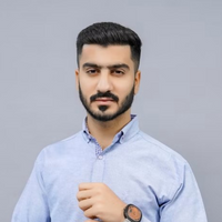 Man wearing a light blue shirt against a gray background