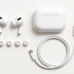 Apple AirPods Pro with charging case and accessories on a white background